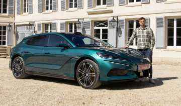 Auto Express senior news reporter Alastair Crooks standing next to the Denza Z9GT EV