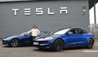 Auto Express senior staff writer Jordan Katsianis standing between two Tesla Model 3s