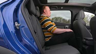 Auto Express news reporter Ellis Hyde sitting in the BYD Atto 3 EVO's rear seat