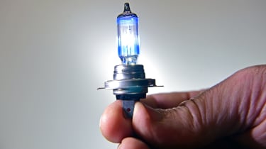 Hand holding a headlight bulb