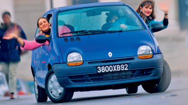 People driving in a blue Renault Twingo - front shot.