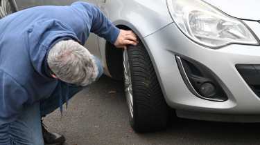 Auto Express consumer editor Chris Rosamond inspecting a Vauxhall Corsa's tyre