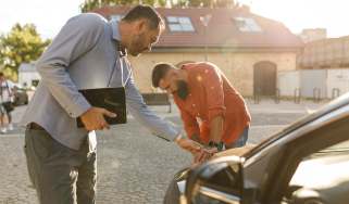 Two people inspecting a used car