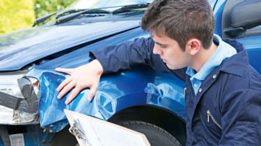 Technician inspecting a car&#039;s cosmetic damage 
