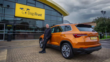 Auto Express staff photographer Pete Gibson standing with the Skoda Karoq outside of a Dogs Trust centre