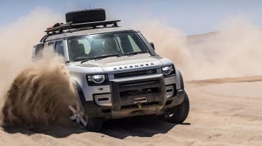 Land Rover Defender driving through sand