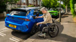 Wheelchair user plugging a charging cable into a Vauxhall Astra Electric