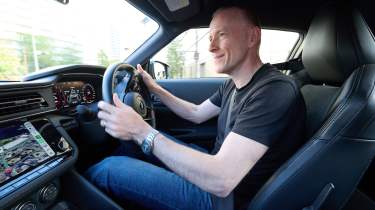 Auto Express editor-at-large Phil McNamara standing driving the Nissan Z