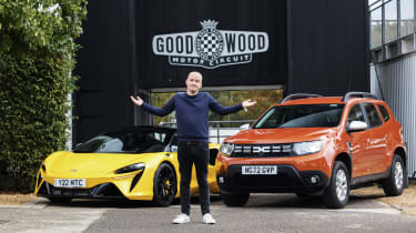 Auto Express chief reviewer Alex Ingram standing in front of the Dacia Duster and McLaren Artura outside Goodwood circuit