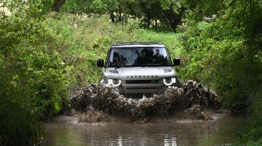 Land Rover Defender driving through a ford
