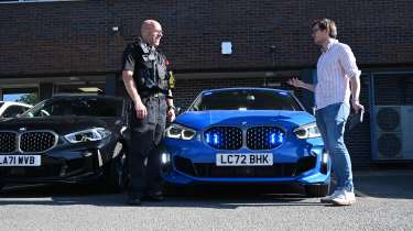 Auto Express consumer reporter Tom Jervis talking to PC Mark Jones in front of a police BMW 1 Series