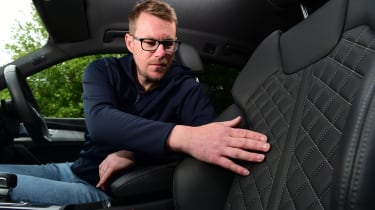 Auto Express associate editor Sean Carson touching the Audi SQ5&#039;s front passenger seat