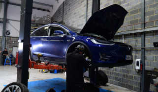 Tesla Model X on two-post inspection ramp