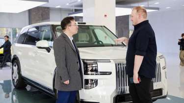 Auto Express news reporter Ellis Hyde and Geely UK managing director Mike Yang standing in front of a Zeekr 9X