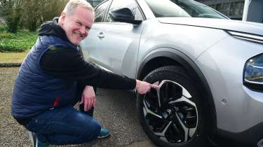 Auto Express executive editor Paul Adam pointing at the Citroen C4 X&#039;s front offside wheel
