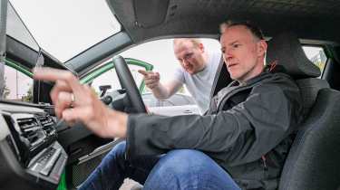 Auto Express news reporter Ellis Hyde demonstrating the Dacia Spring&#039;s infotainment system to Auto Express editor-at-large Phil McNamara