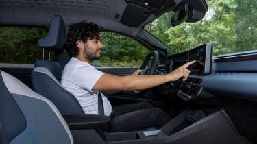 Auto Express senior staff writer Jordan Katsianis operating the Nissan Micra EV&#039;s infotainment system