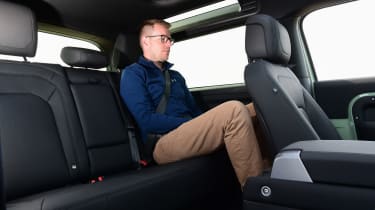 Auto Express associate editor Sean Carson sitting in the back seat of the Land Rover Defender 90
