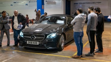 Auction bidders inspecting a Mercedes E-Class Cabriolet