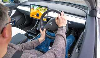 Auto Express editor Paul Barker playing video games in a Tesla