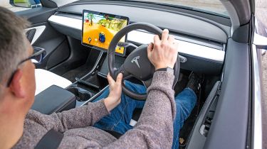 Auto Express editor Paul Barker playing video games in a Tesla