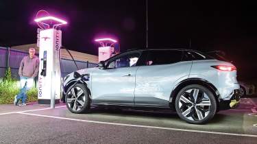 Auto Express editor Paul Barker standing next to a Renault Megane E-Tech and a set of Ionity chargepoints