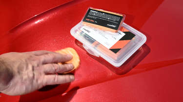 Auto Express products editor Tom Barnard using a CarPro Mild Clay bar on a Skoda Superb