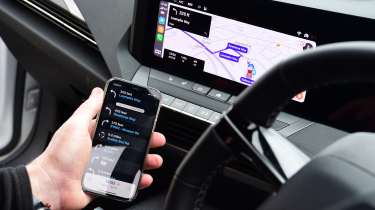 Auto Express products editor Kim Adams connecting a smartphone to the Vauxhall Astra GSe&#039;s infotainment system