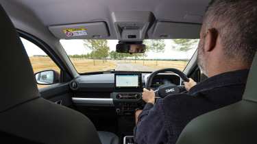 Dacia Spring Extreme - front interior, car being driven by Auto Express deputy editor Richard Ingram