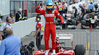 Fernando Alonso stands on his car after winning the German Grand Prix