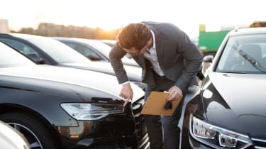 Salesman inspecting a car