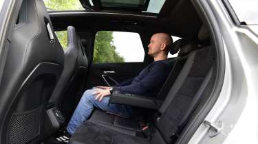 Tesla Model Y - rear seats being sat in by Auto Express chief reviewer Alex Ingram 