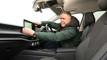 Auto Express senior photographer Pete Gibson holding the Skoda Superb&#039;s infotainment screen