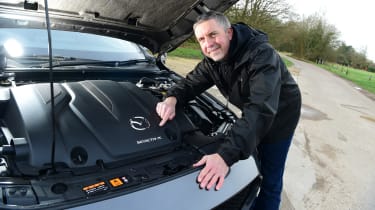 Auto Express senior photographer Pete Gibson pointing at the Mazda 3&#039;s engine