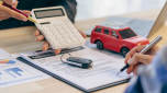 Finance contract, car key and calculator on desk