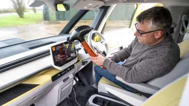 Auto Express editor Paul Barker hitting the Volkswagen ID. Buzz&#039;s dashboard with an inflatable hammer