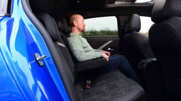 Auto Express chief reviewer Alex Ingram sitting in the Vauxhall Astra Electric&#039;s back seat