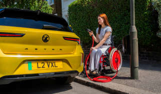Wheelchair user charging a Vauxhall Astra Electric