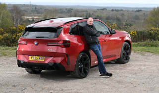 Auto Express Phil McNamara leaning against the BMW X3 30e xDrive M Sport