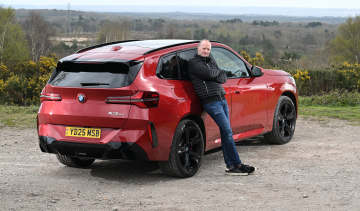Auto Express Phil McNamara leaning against the BMW X3 30e xDrive M Sport