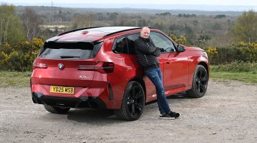 Auto Express Phil McNamara leaning against the BMW X3 30e xDrive M Sport