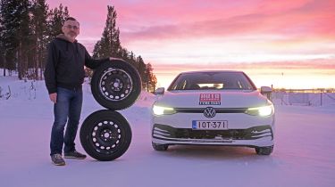 John Barker standing next to two wheels and a VW Golf