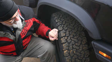 Auto Express senior test editor Dean Gibson inspecting the Ineos Grenadier&#039;s tyre