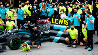 Lewis Hamilton sitting with pit crew
