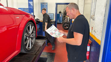 Auto Express special contributor Steve Sutcliffe discussing the Audi TT&#039;s damaged wheels with a technician