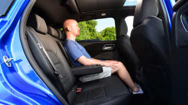 Nissan Qashqai - rear seats being sat in by Auto Express chief reviewer Alex Ingram 