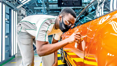 Person polishing car on production line