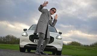 Auto Express consumer reporter Tom Jervis standing in front of the Suzuki Swift while wearing sunglasses