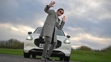 Auto Express consumer reporter Tom Jervis standing in front of the Suzuki Swift while wearing sunglasses