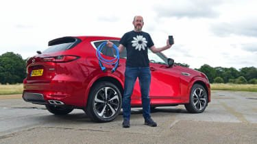 Auto Express chief sub-editor Andy Pringle standing in front of the Mazda CX-60 and holding a charging cable